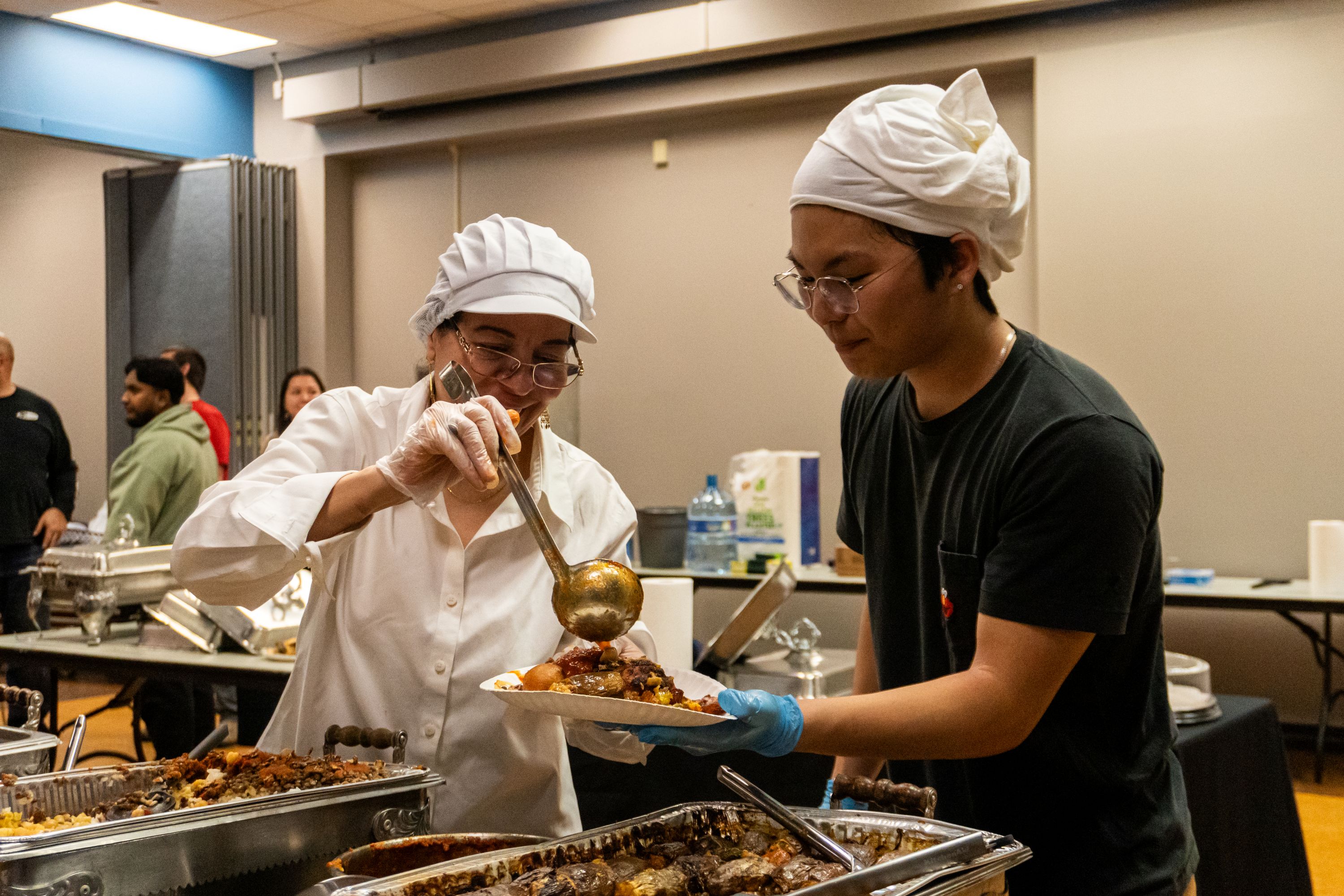 A person serving another person noodles